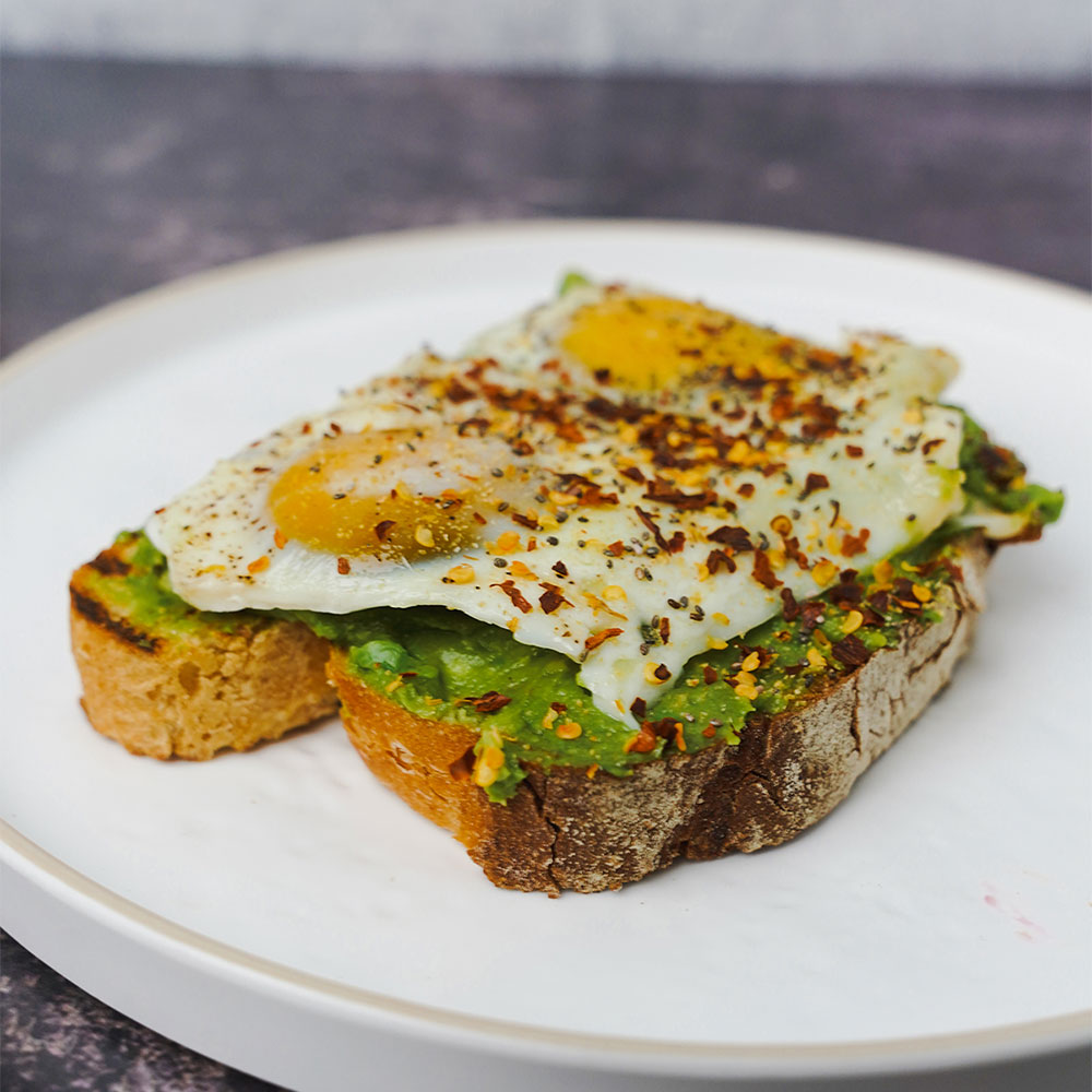 Avocado Toast with egg on top made at our Astoria breakfast place and cafe.