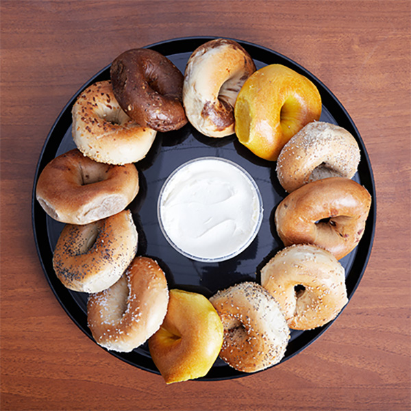 A circular tray of bagels with cream cheese in the middle, a popular option with our Midtown West, Manhattan, NY lunch catering services.