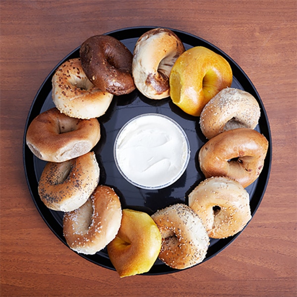 A circular tray of bagels with cream cheese in the middle, a popular option with our Williamsburg, Brooklyn, NY lunch catering services.
